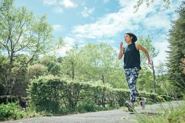 自然の中をジョギングをする女性