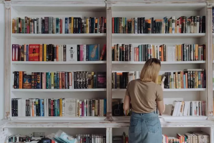 本棚で本を選ぶ女性