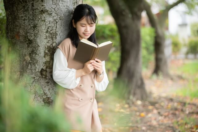 公園で本を読む女性