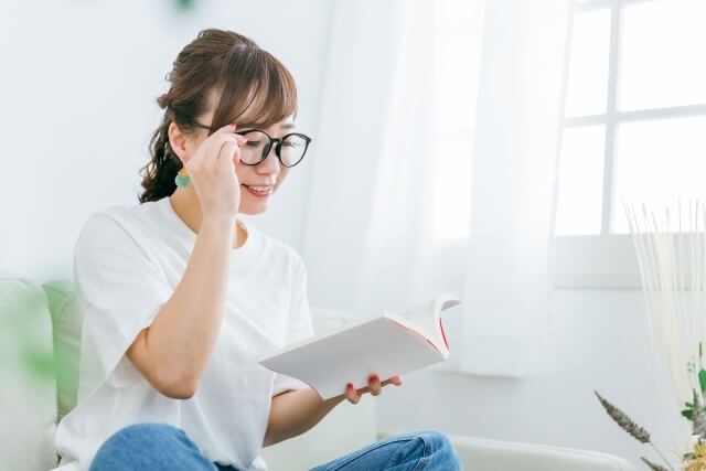 メガネをかけて本を読むアジア人女性