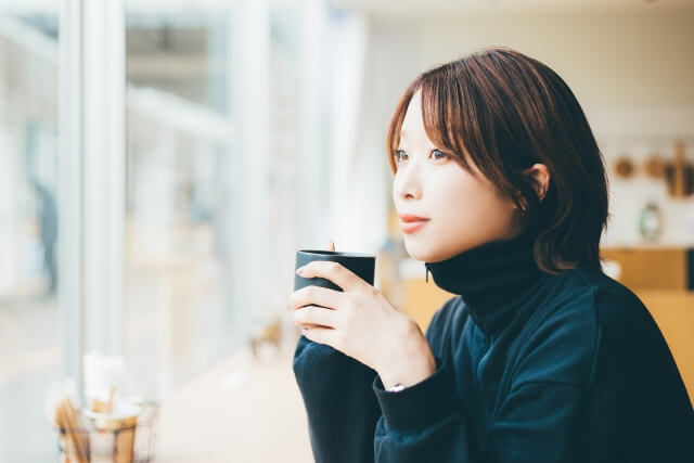 のんびりとカフェでコーヒーを飲む女性