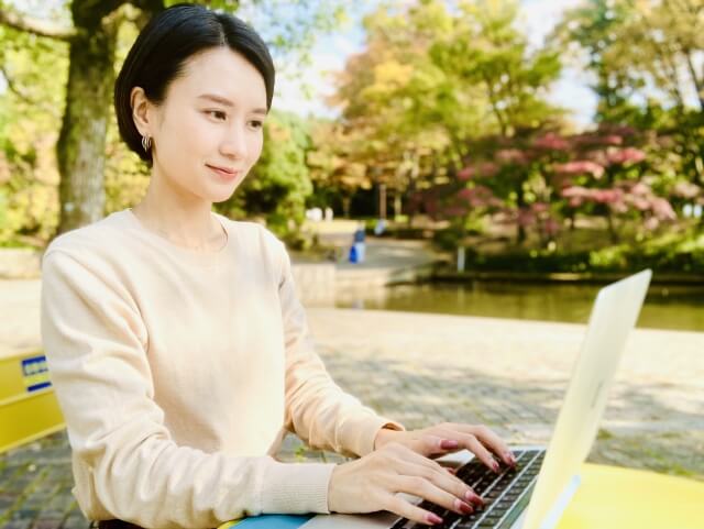 公園でパソコン作業をする女性