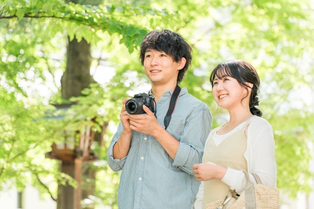 旅行先でカメラで写真を撮る男性と女性