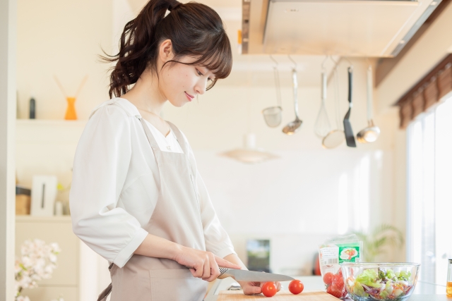 包丁でトマトを切る女性