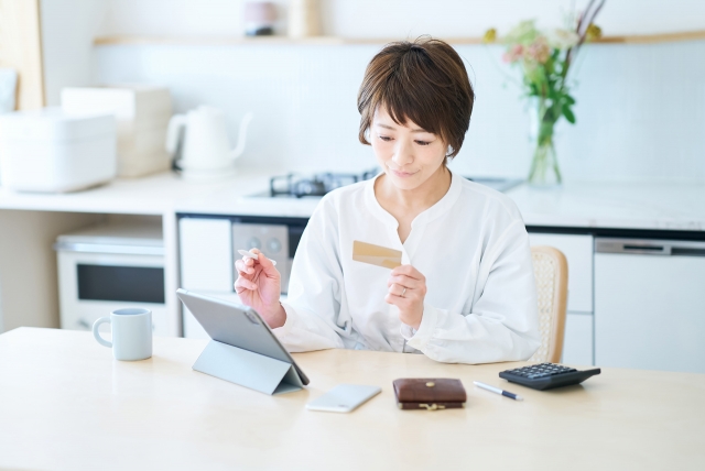 カードを持ってPCを操作する女性