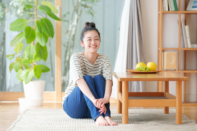 カメラ目線でお姉さん座りするジーンズの女性