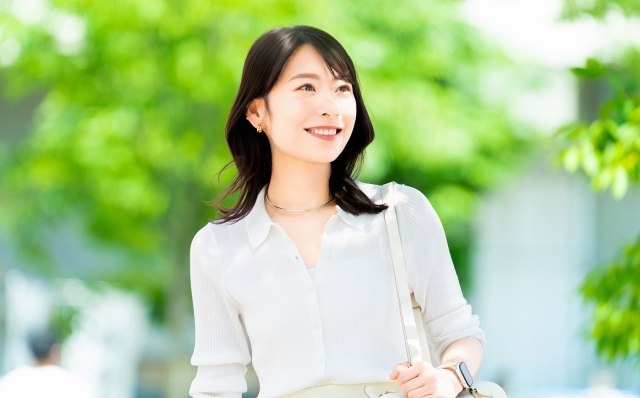 屋外を歩く笑顔の女性